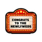 Decorative sign with 'Congrats to the Newlyweds' text on a white background